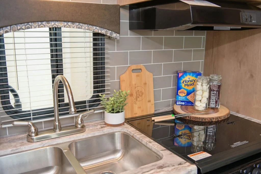 Kitchenette with a sink and stove inside of the best RV rental in South Florida